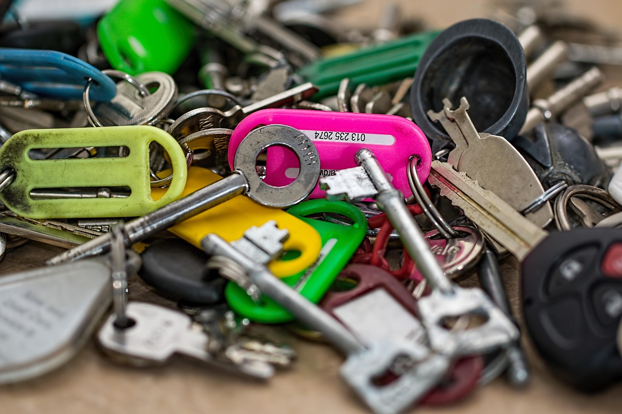 A pile of assorted keys and keyrings in different colours, jumbled together on a table
